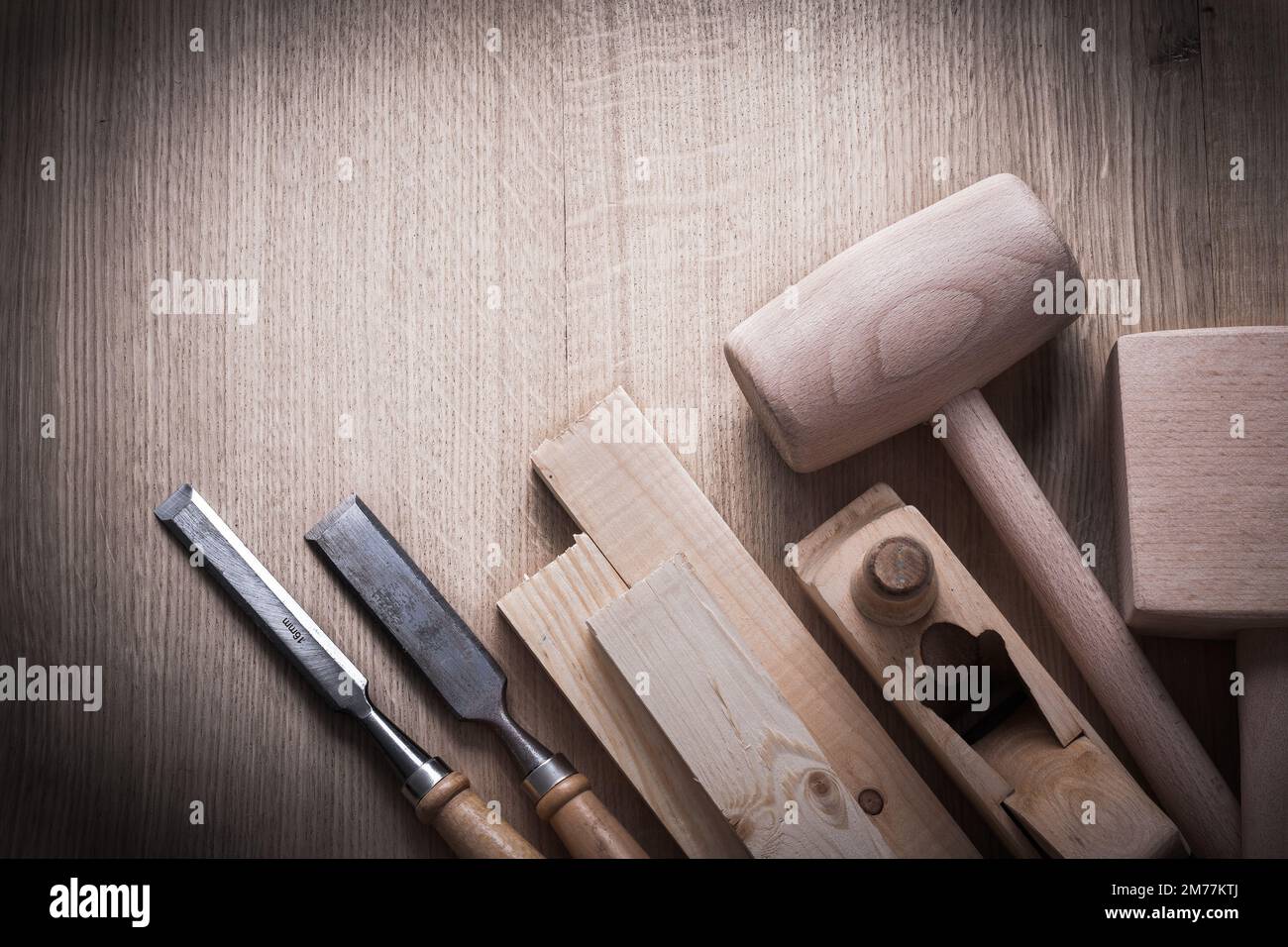 Wooden planks hammers planner flat chisels on wood background construction concept. Stock Photo