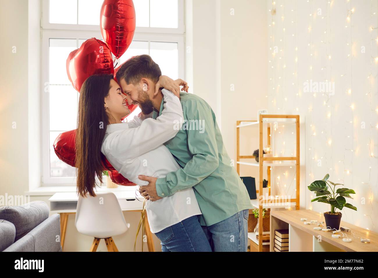 Happy young couple hugging and kissing at home Stock Photo - Alamy