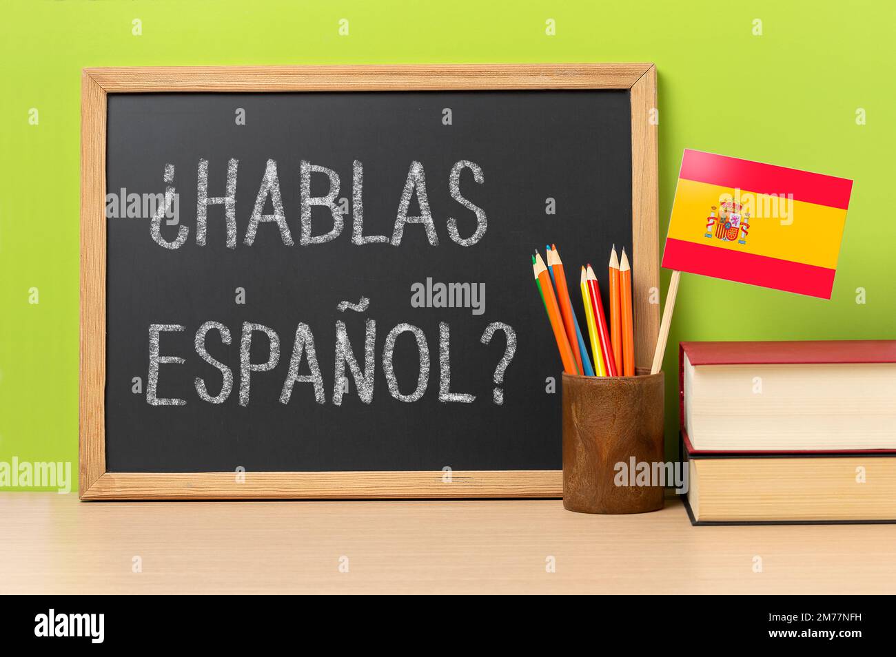 A chalkboard with the question hablas espanol? do you speak Spanish? written in Spanish, a pot