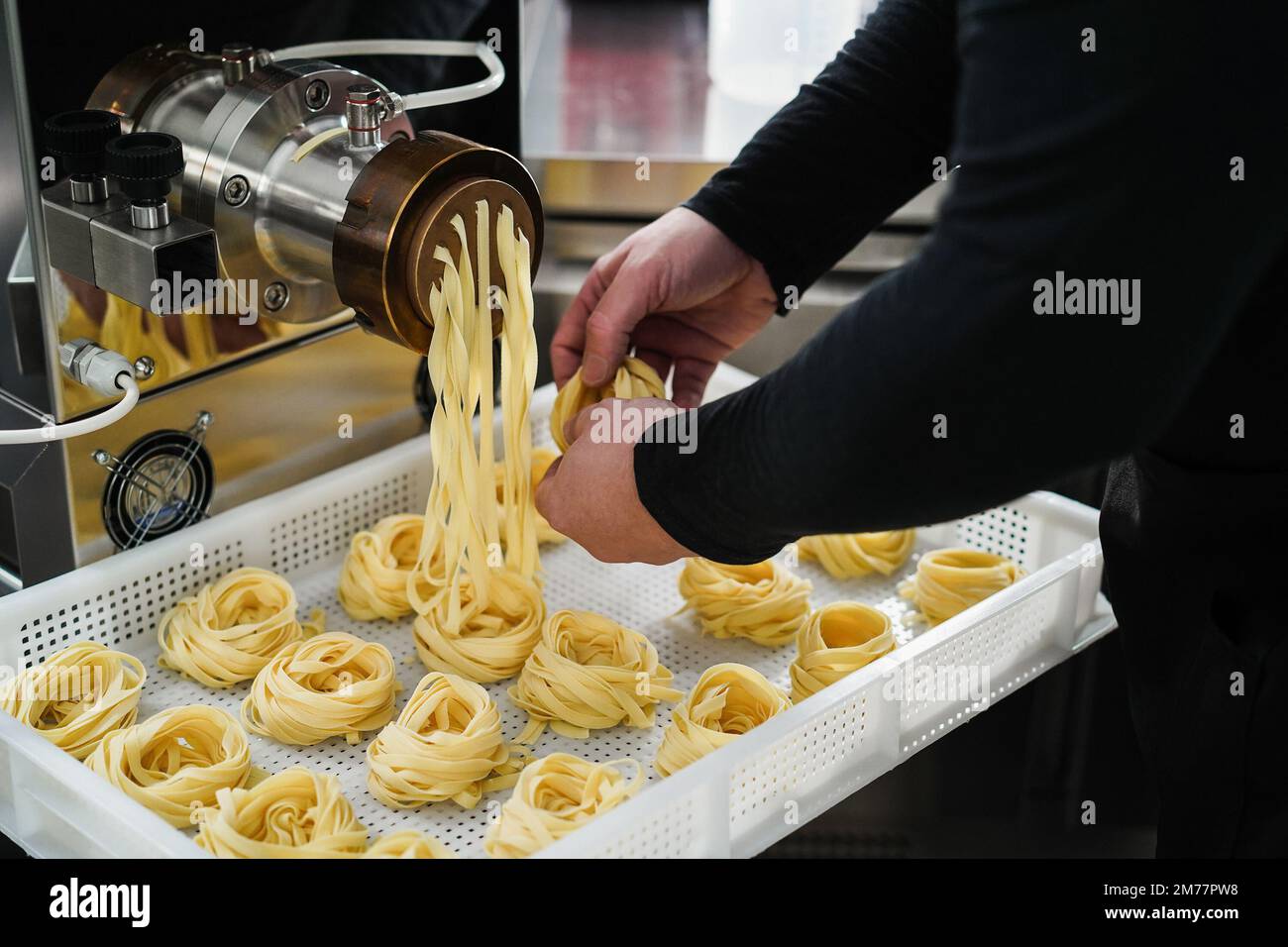 Chef working with pasta manufacture machine Stock Photo