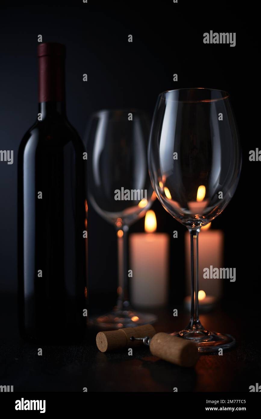 Elegant red wine glass and a wine bottle in black background Stock