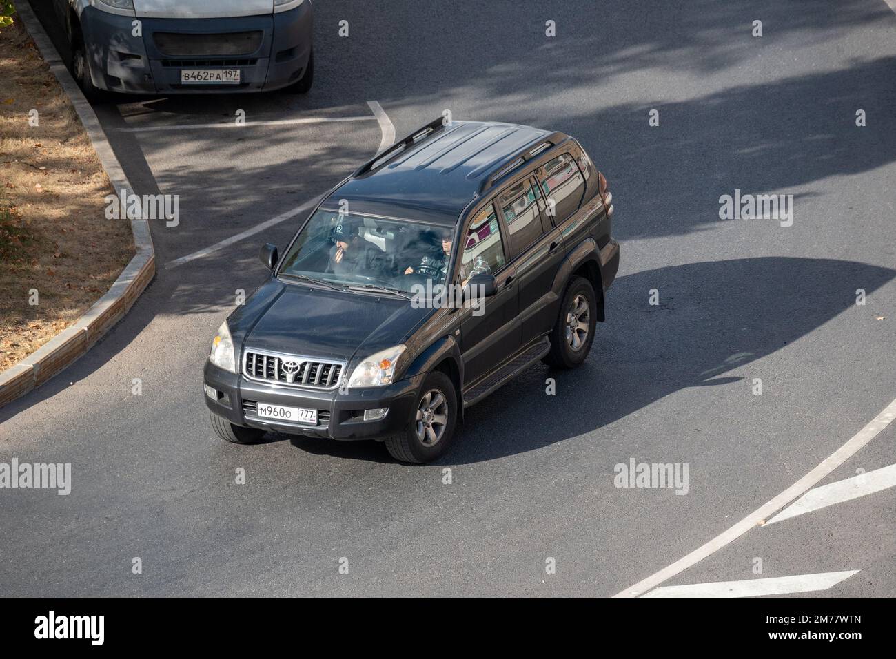 Moscow, Russia - September 27, 2022: Black Japanese SUV Toyota Land Cruiser Prado 120 2002 is driving on the road in the city ( Lexus GX) Stock Photo