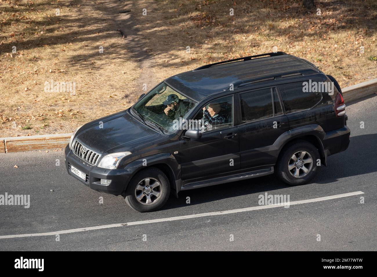 Moscow, Russia - September 27, 2022: Black Japanese SUV Toyota Land Cruiser Prado 120 2002 is driving on the road in the city ( Lexus GX) Stock Photo