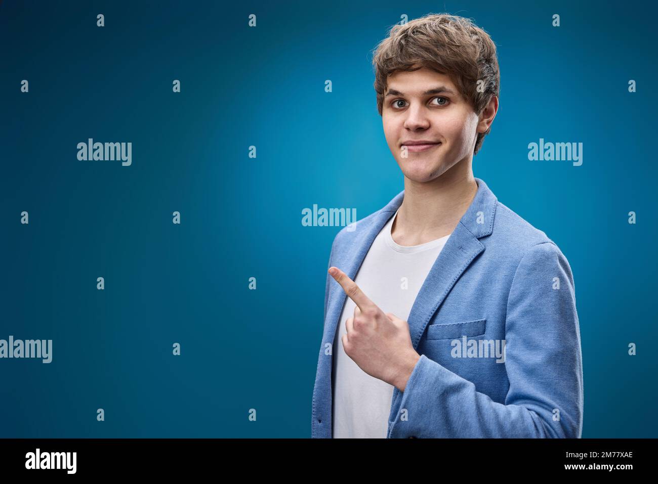 young man in jacket pointing at copy space Stock Photo