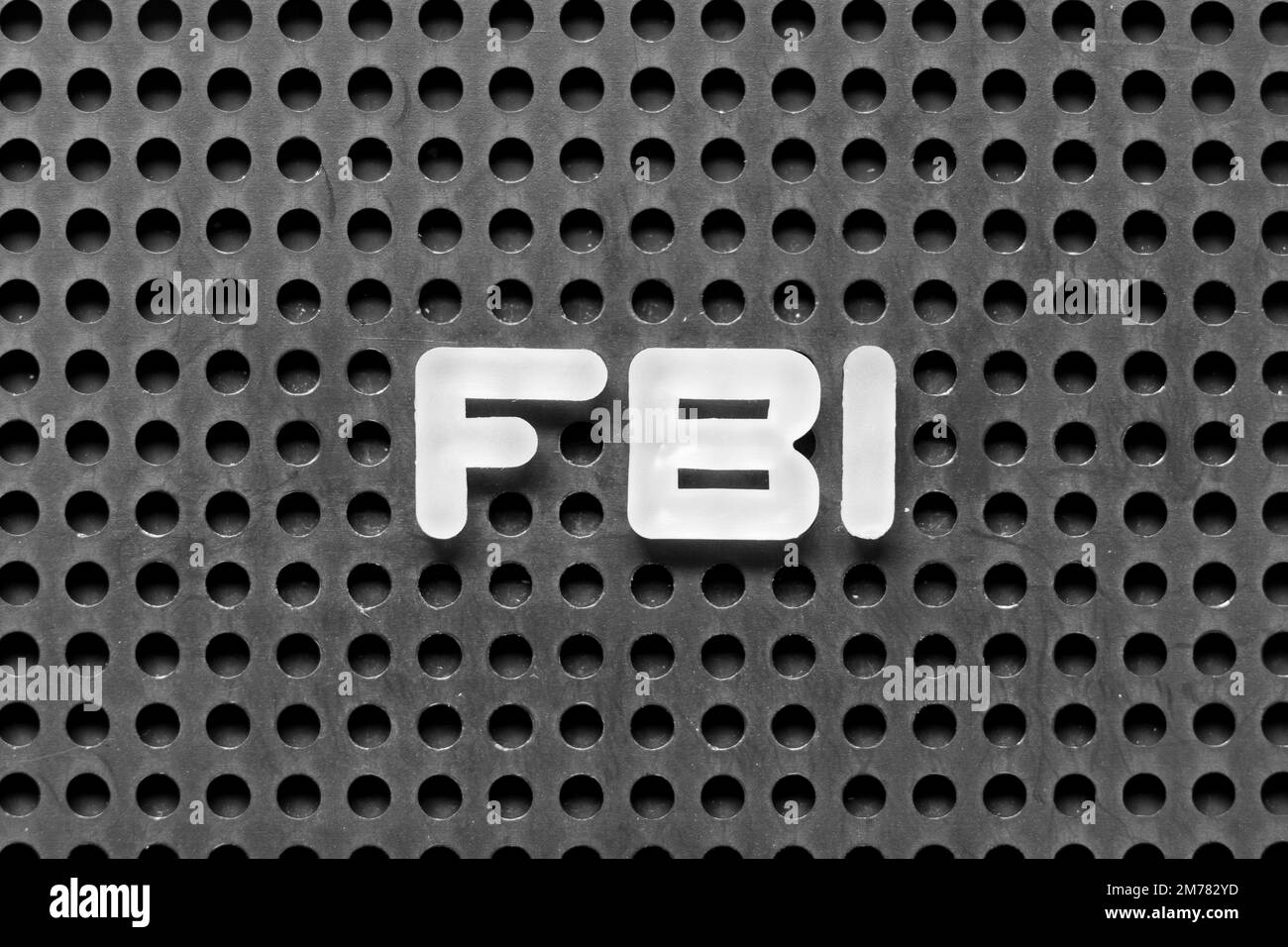 White alphabet letter in word FBI (Abbreviation of Federal Bureau of Investigation) on black pegboard background Stock Photo