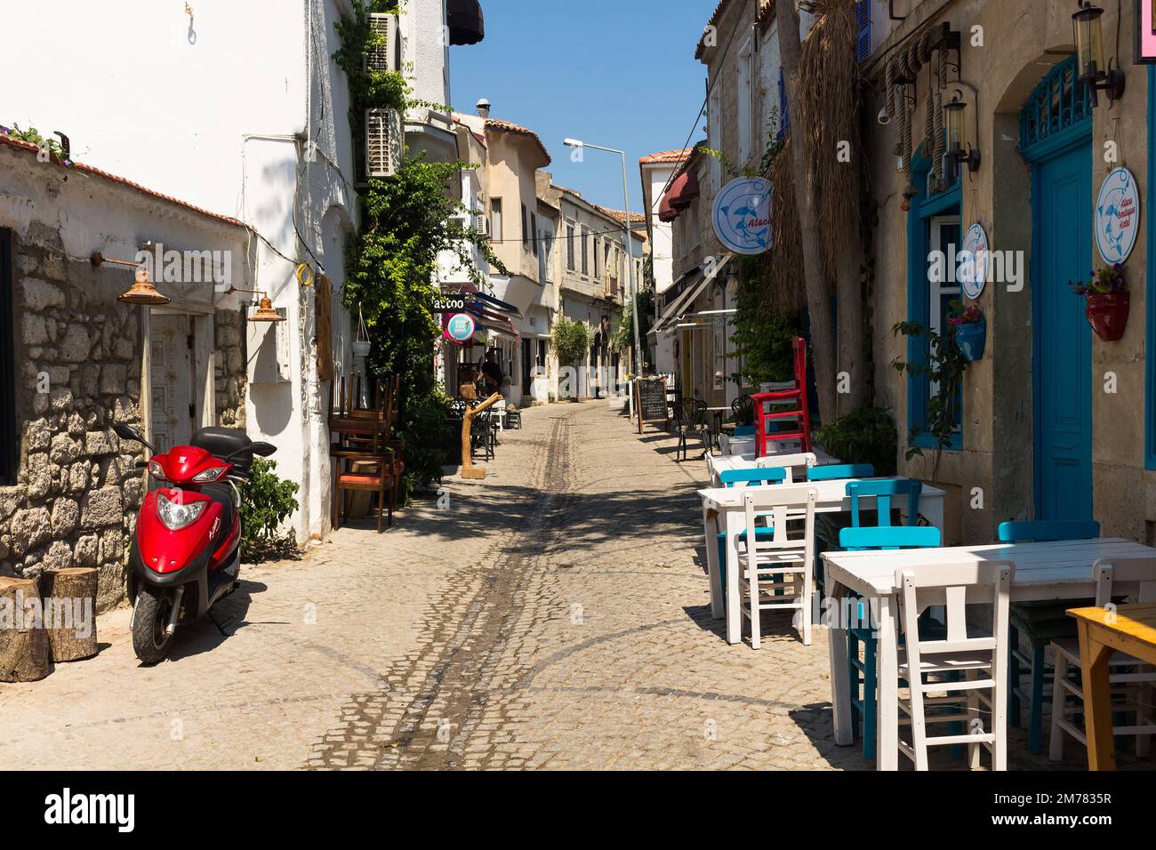 View of a narrow street and old, historical, traditional stone houses in famous, touristic Aegean town called Alacati. It is a village of Cesme, Turke Stock Photo