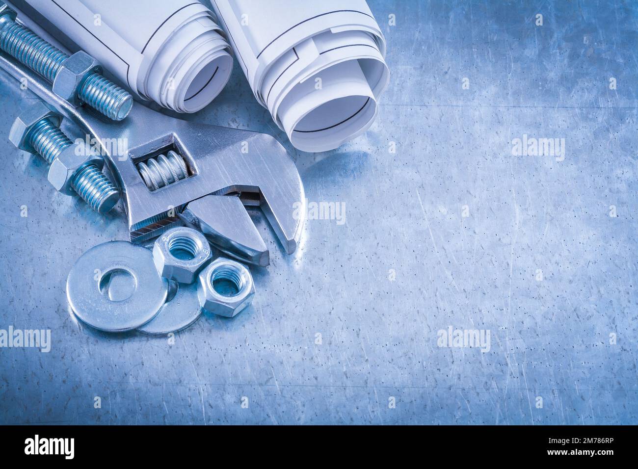 Adjustable spanner bolt washers construction nuts screwbolts and rolled up blueprints on