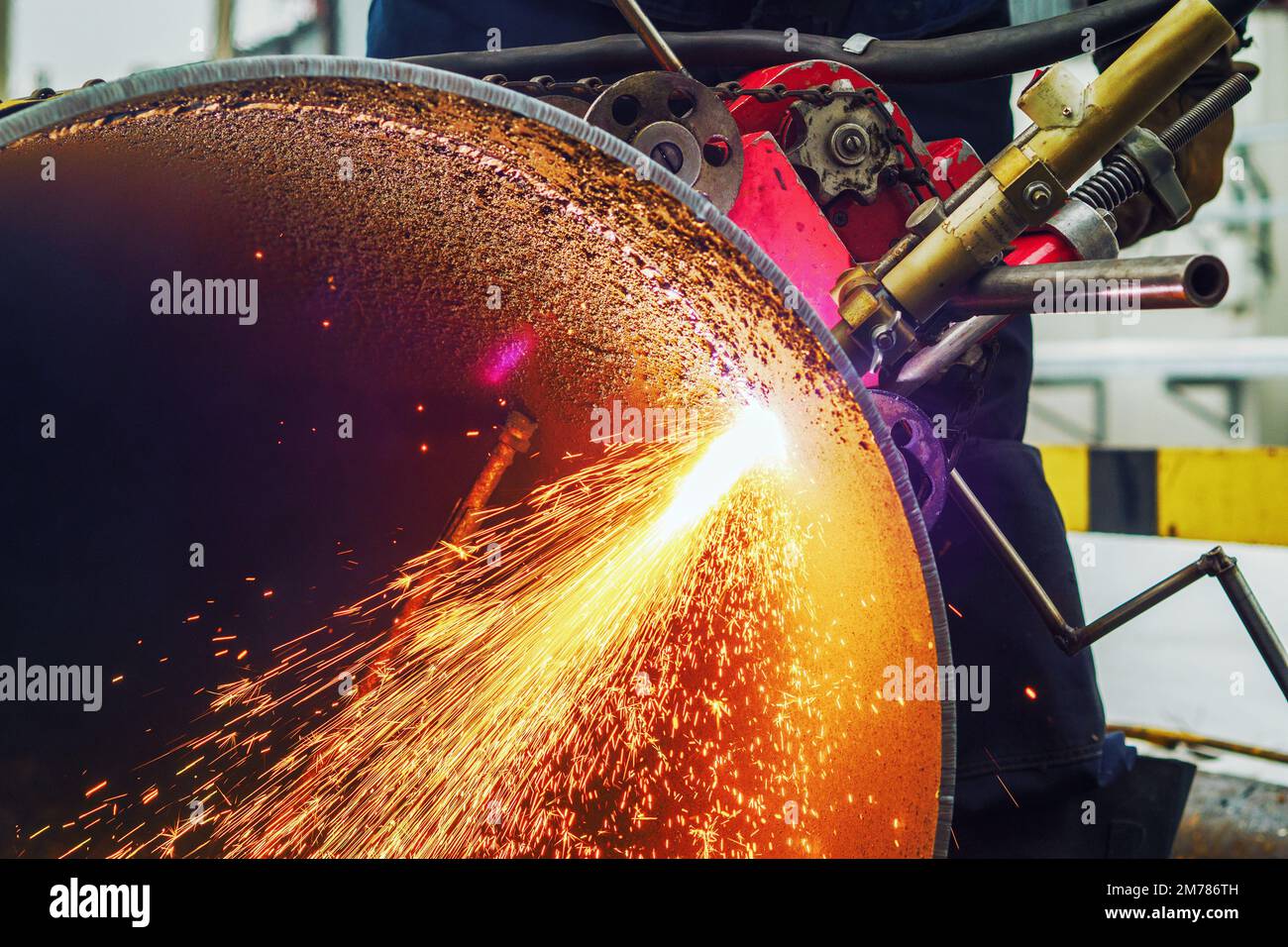 Working welder cuts metal and sparks fly. Gas cutting of large diameter