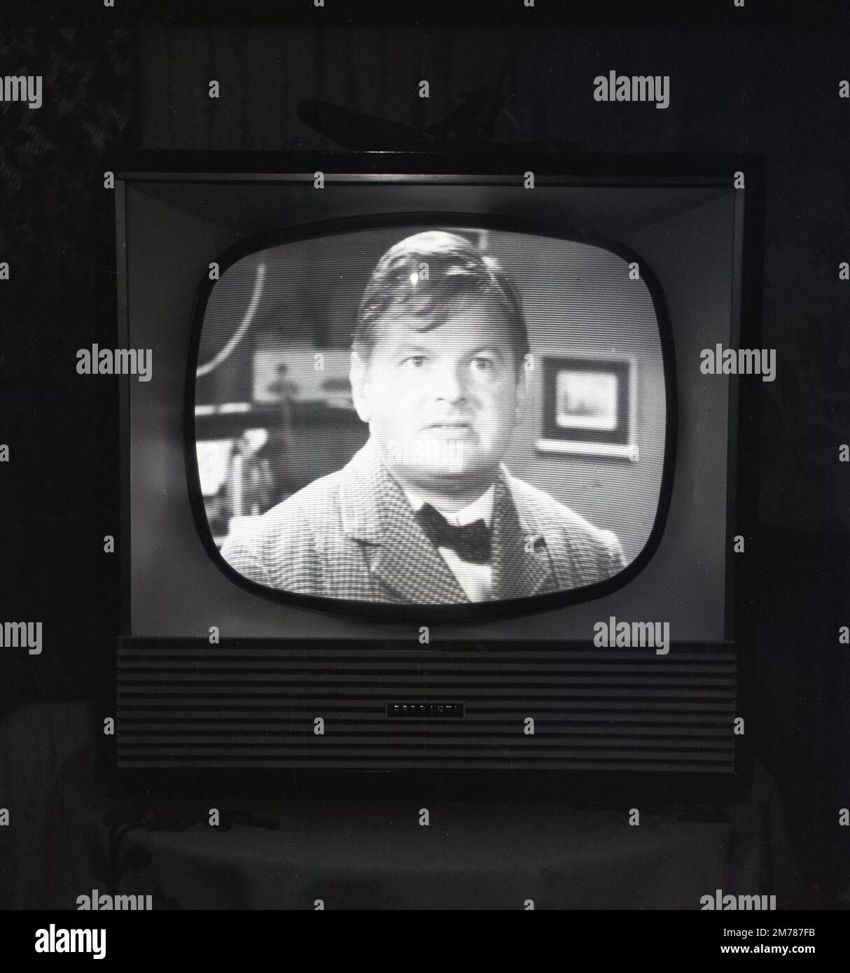 1957, historical, the comedian Benny Hill on BBC television being broadcast on a Briitsh made Ferranti  television set. A sketch comedy programme, The Benny Hill Show was first broadacst on the BBC in 1955. Benny Hill would go on to become one of the most popular figures on British television, with one of his 1970s show's being watched by 21 million viewers. Founded in 1882, Lancashire based Ferraniti, was a leading valve, radio and television manufacturer,  later to become a major British electrical engineering company. It's radio and television set division was sold to rival ECKO in 1957. Stock Photo