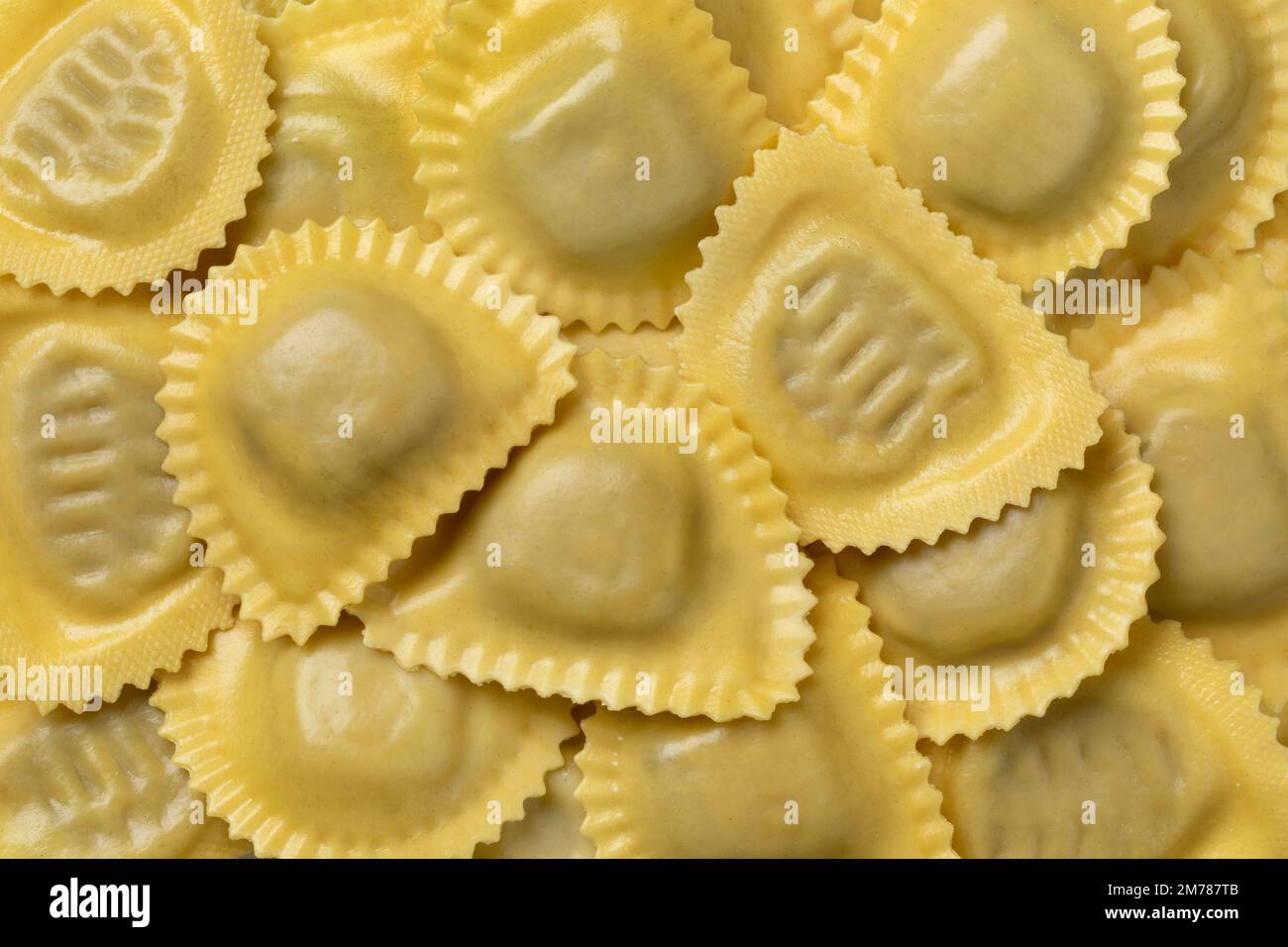Traditional fresh Italian Mezzelune pasta stuffed with Mozzarella and mushrooms close up full frame as background Stock Photo
