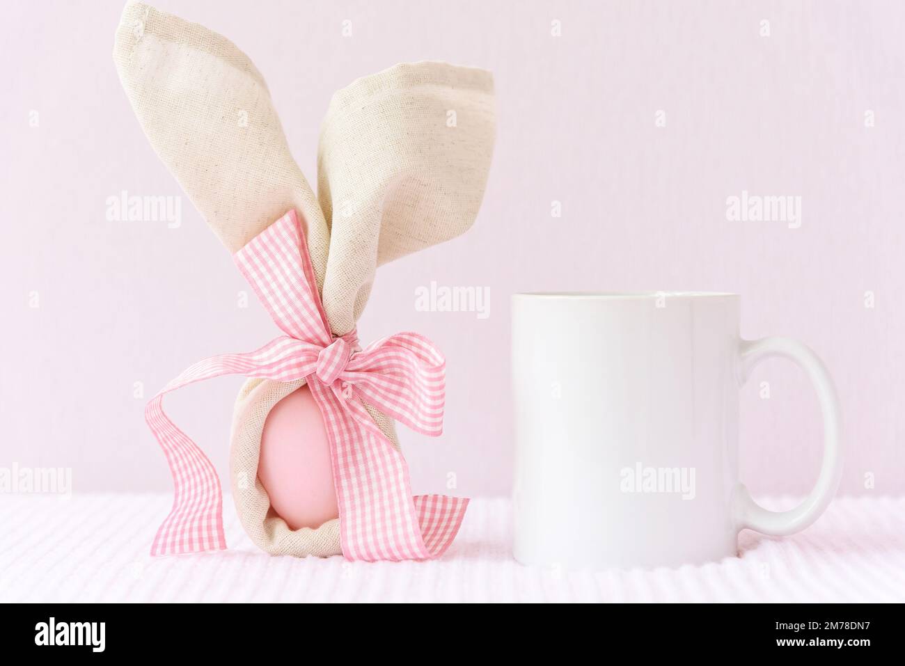 https://c8.alamy.com/comp/2M78DN7/easter-mockup-white-mug-with-bunny-ears-at-egg-on-pink-cover-background-2M78DN7.jpg