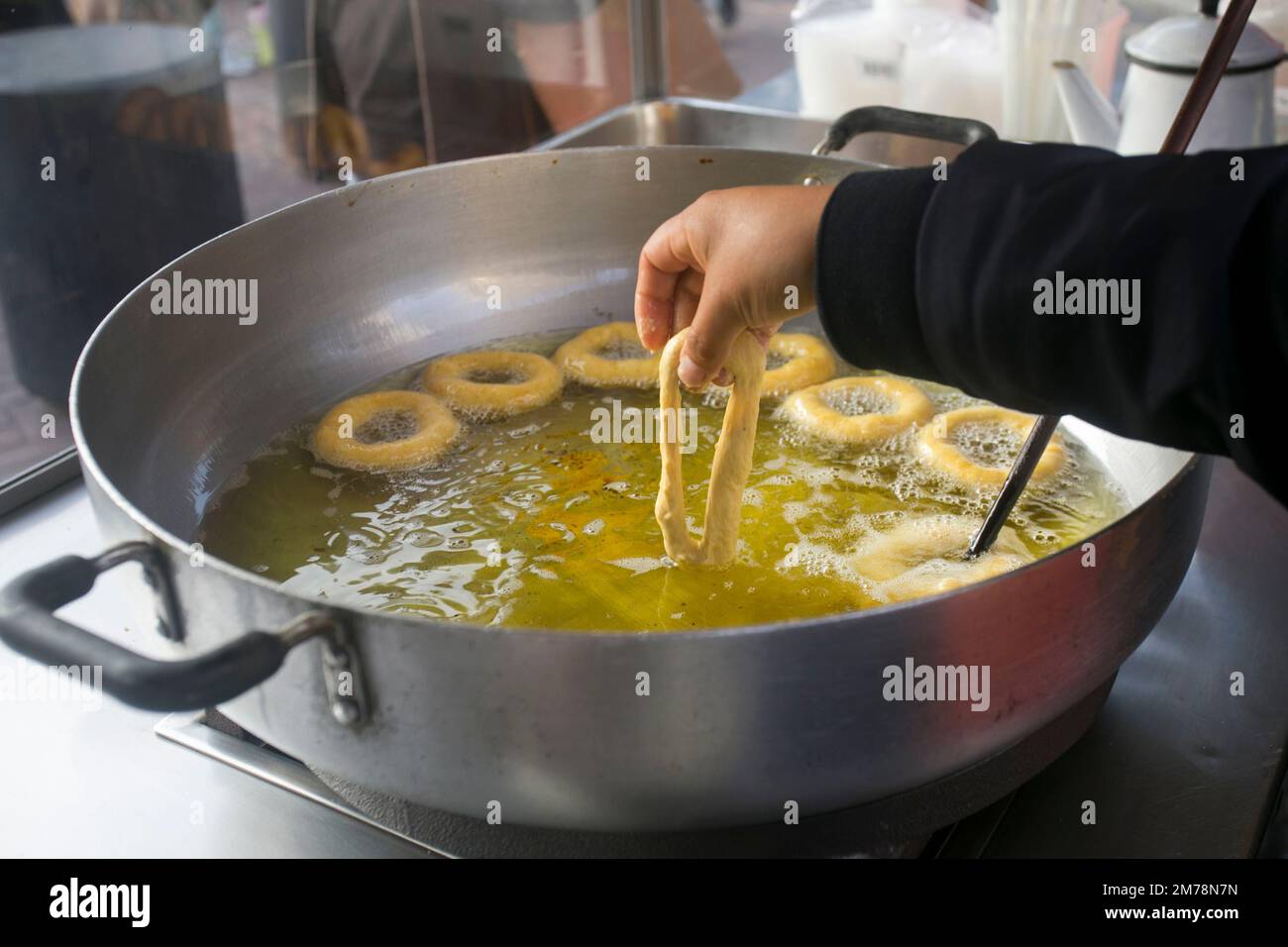 Picarones are ring-shaped fried sweets made with wheat flour dough mixed with squash, and sometimes sweet potato, bathed in flavored chancaca honey. Stock Photo