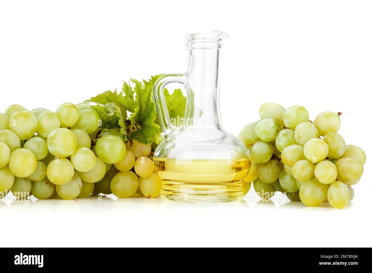 Grape seed oil on white background. The image also shows light grapes and dark grapes arranged on a white background Stock Photo