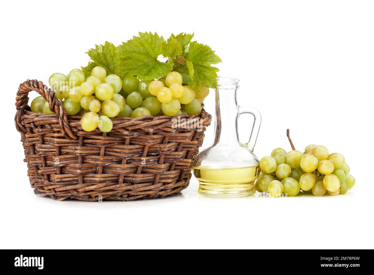 Grape seed oil on white background. The image also shows light grapes and dark grapes arranged on a white background Stock Photo