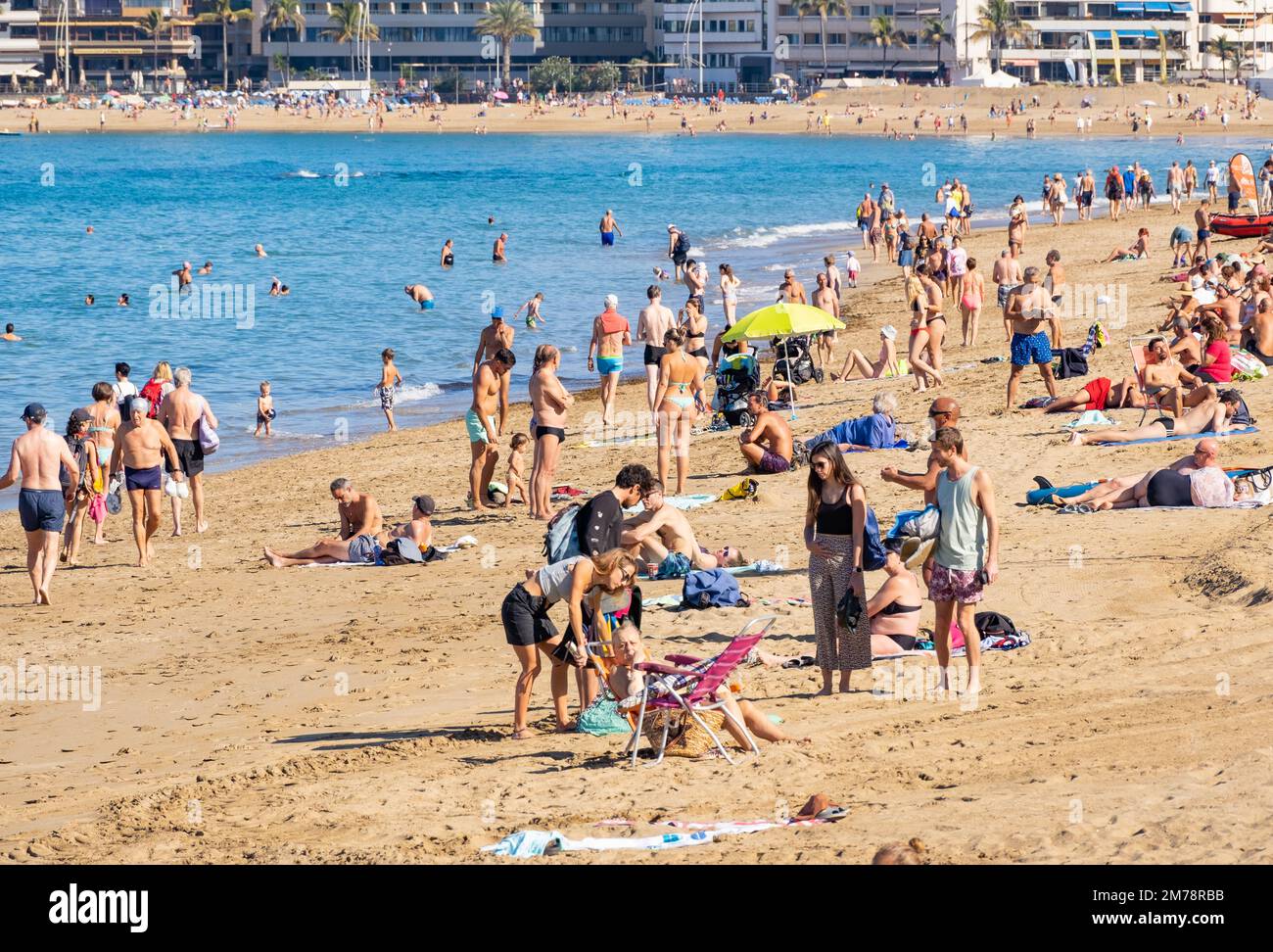 Las Palmas, Gran Canaria, Canary Islands, Spain. 8th January 2023.  Tourists, many from the UK, bask in glorious sunshine on the city beach in Las Palmas. UK holiday firms are expecting a busy weekend for 2023 holidays, with the first Saturday following the new year holiday traditionally one of the peak times for bookings. Credit: Alan Dawson/Alamy Live News Stock Photo