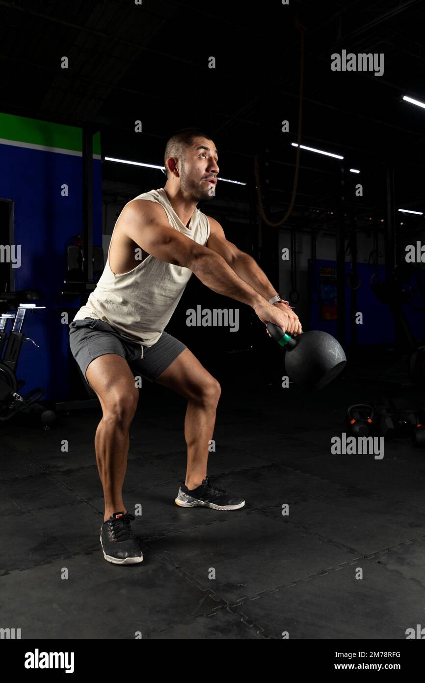 muscular mexican man swinging a kettlebell Stock Photo
