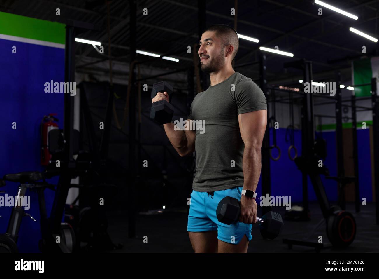 vertical image of a latin athlete, doing bicep exercises with two