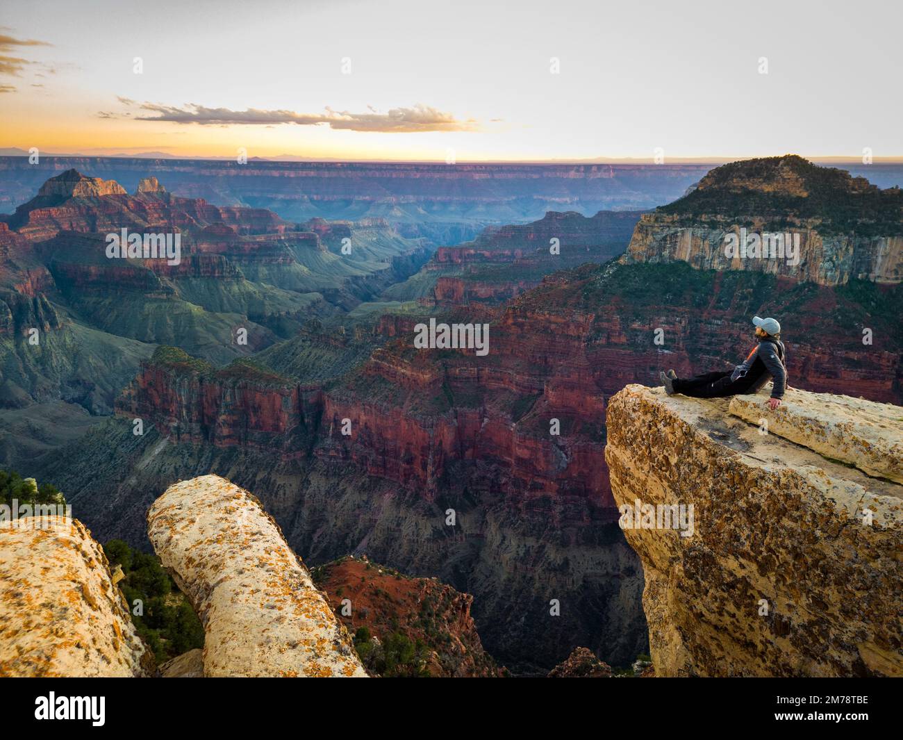 person sitting on the edge of grand canyon Stock Photo - Alamy