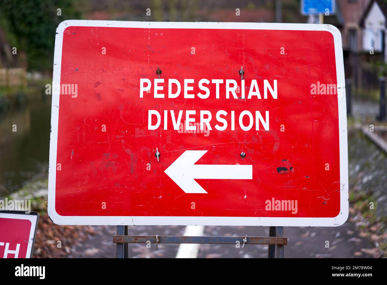 Bright red pedestrian diversion sign with white arrow Stock Photo Alamy