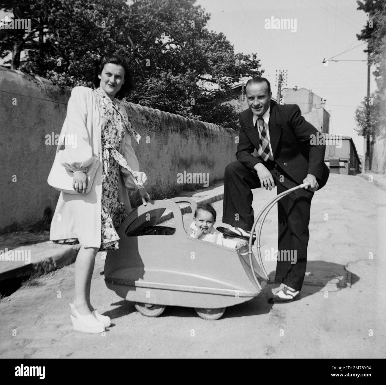1940s Young French Couple and Child, Infant, Baby or Toddler in Vintage 1940s Baby Stroller, Pram or Perambulor in Streets of Old Marseille France 1945. Vintage Black and White or Monochrome Photograph. Stock Photo