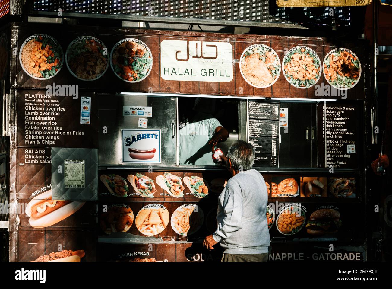 A person buying food from a halal grill kiosk in New York City Stock Photo  - Alamy