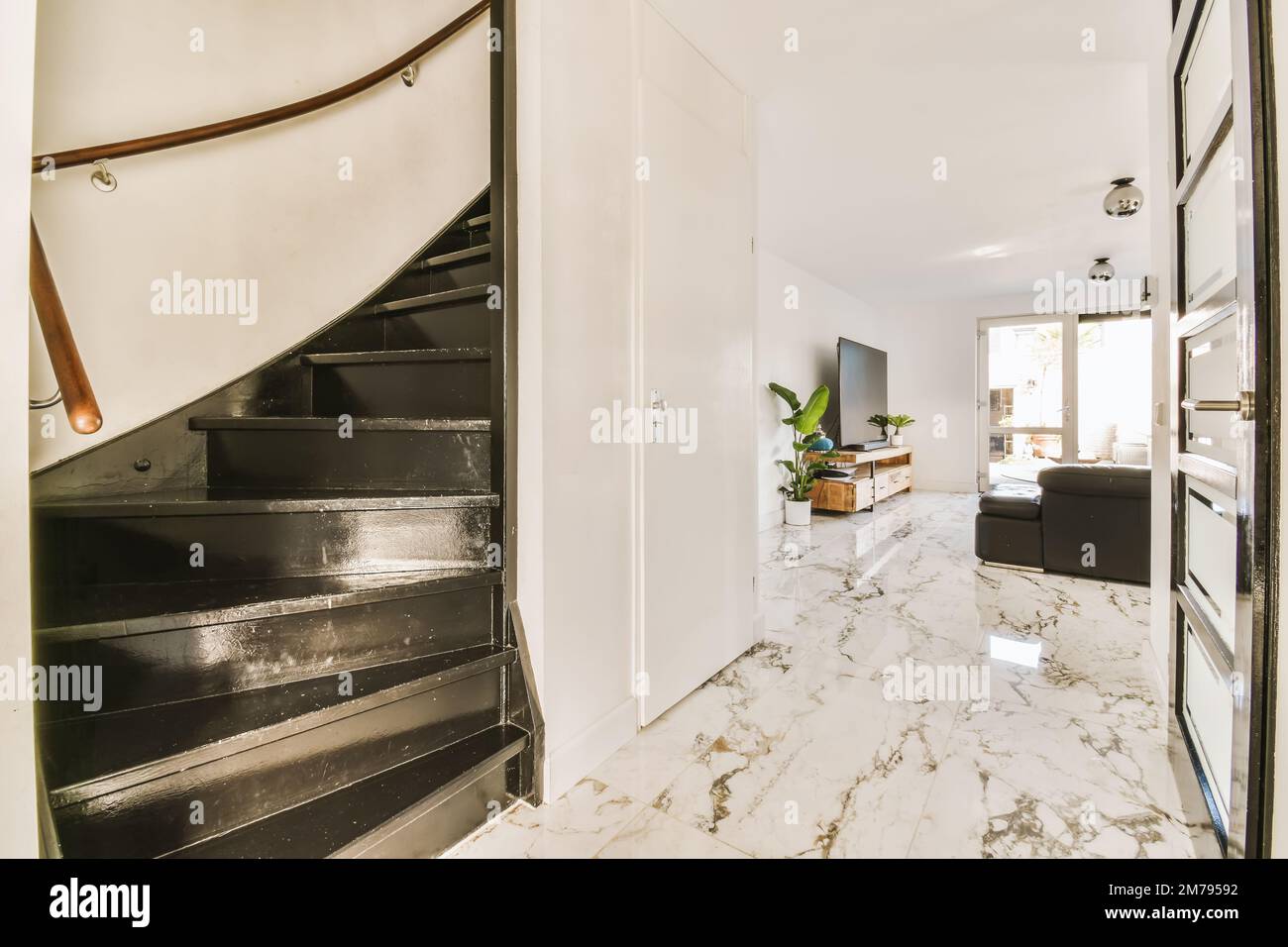 a living room with marble flooring and staircase leading up to the