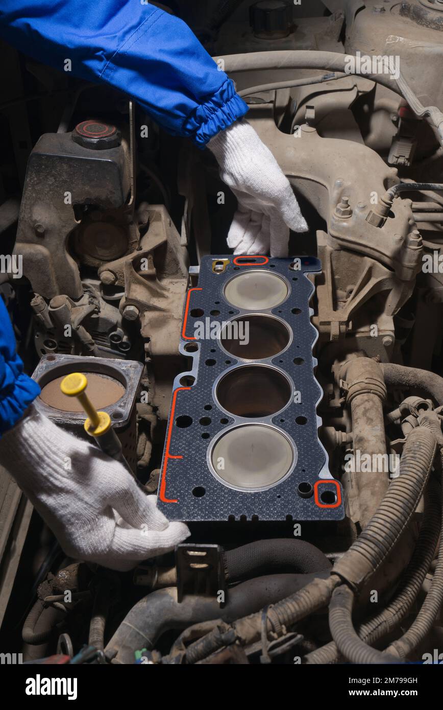 An auto mechanic checks the quality of the car cylinder block gasket