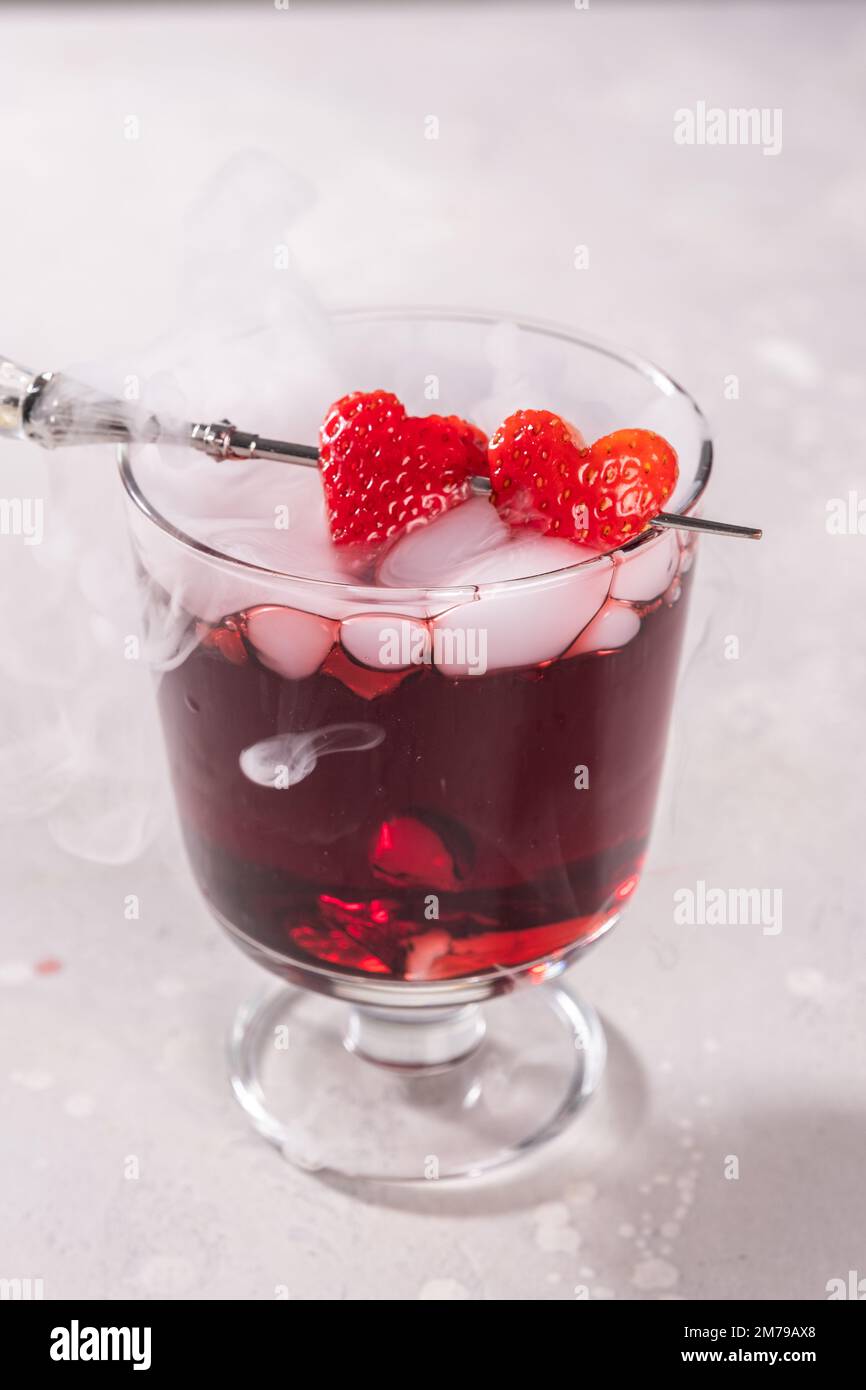 Valentine's day cocktail with dry ice on dark background Stock Photo