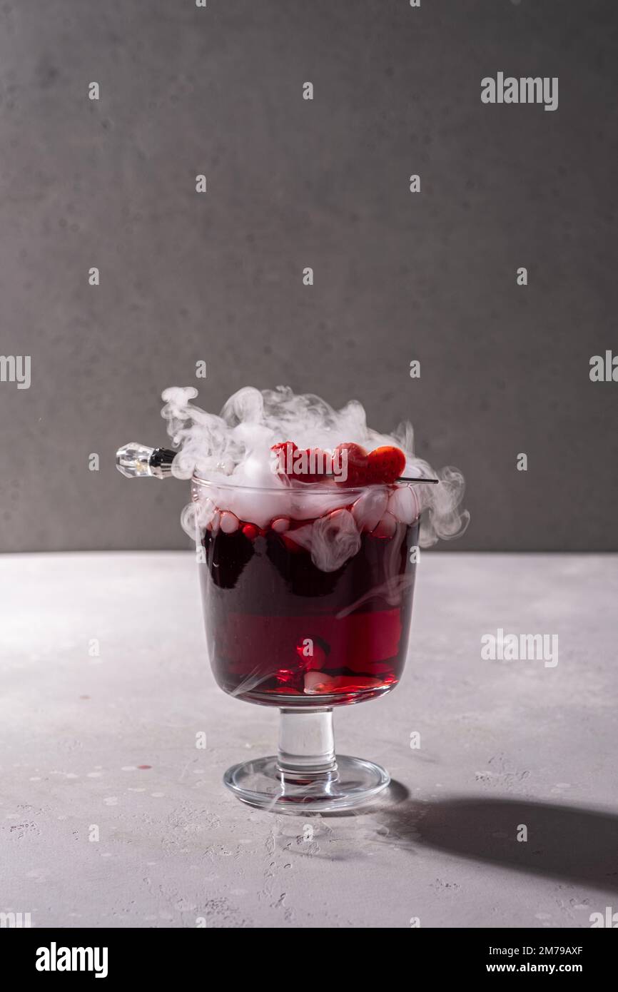 Valentine's day cocktail with dry ice on dark background Stock Photo