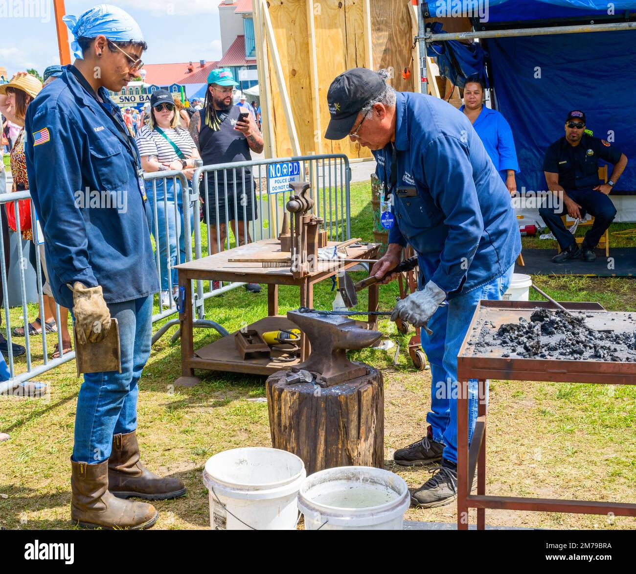 NEW ORLEANS, LA, USA - APRIL 29, 2022: Blacksmith and assistant demonstrating toolmaking craft at the New Orleans Jazz and Heritage Festival Stock Photo
