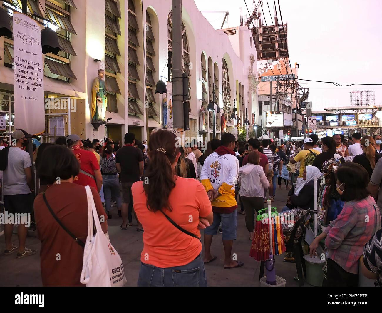 Nazarene devotees stand outside the Quiapo Church to listen to the mass. Catholic devotees flock to Quiapo Church in Manila to express their devotion to the Black Nazarene, a life-sized image of dark skinned, kneeling Jesus Christ carrying the cross. A day before it's feast on January 9. This festive activity was put on hold for two years because of the COVID-19 pandemic. Stock Photo