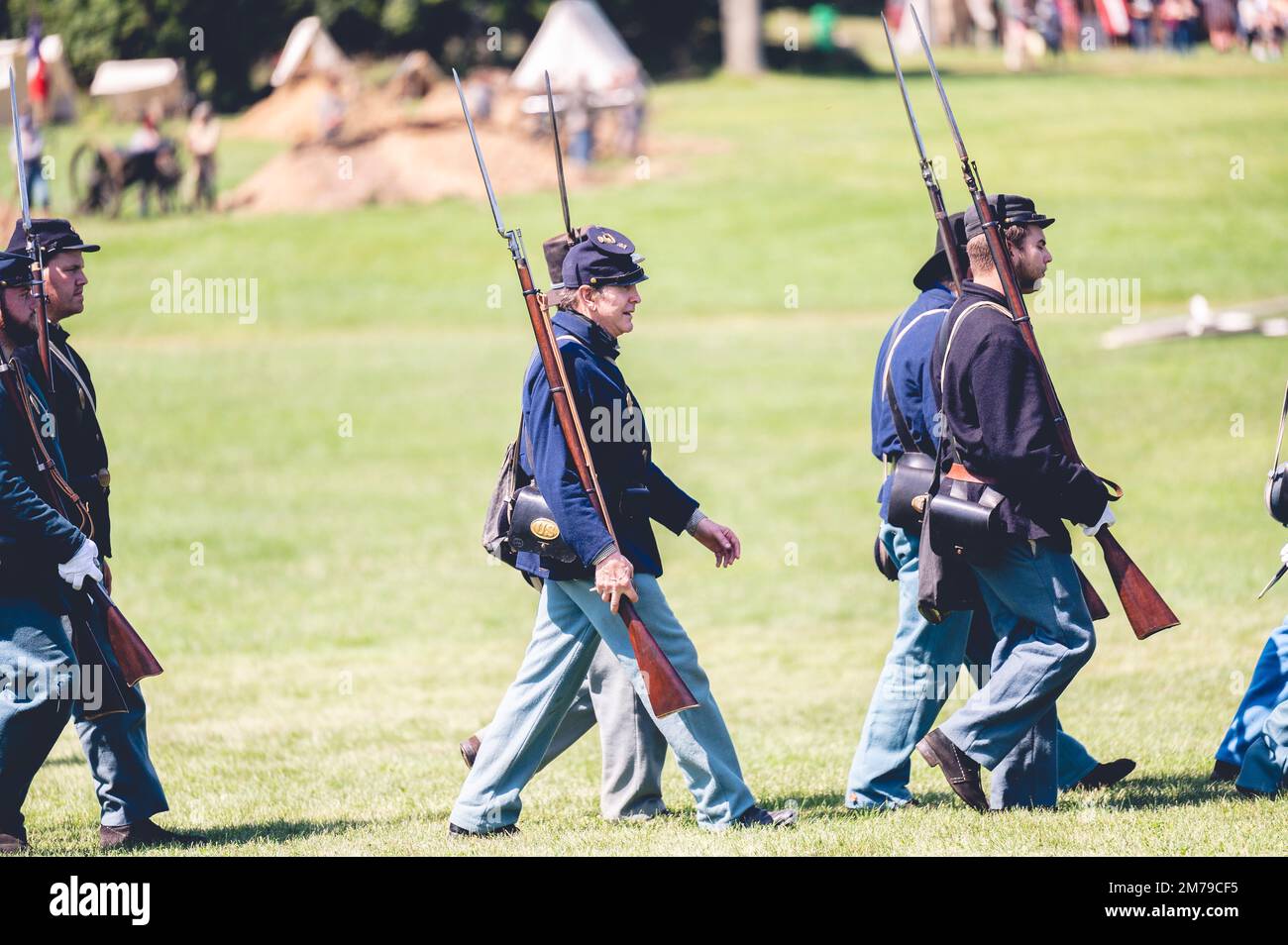 A shallow focus view of soldiers marching at a Civil war reenactment in