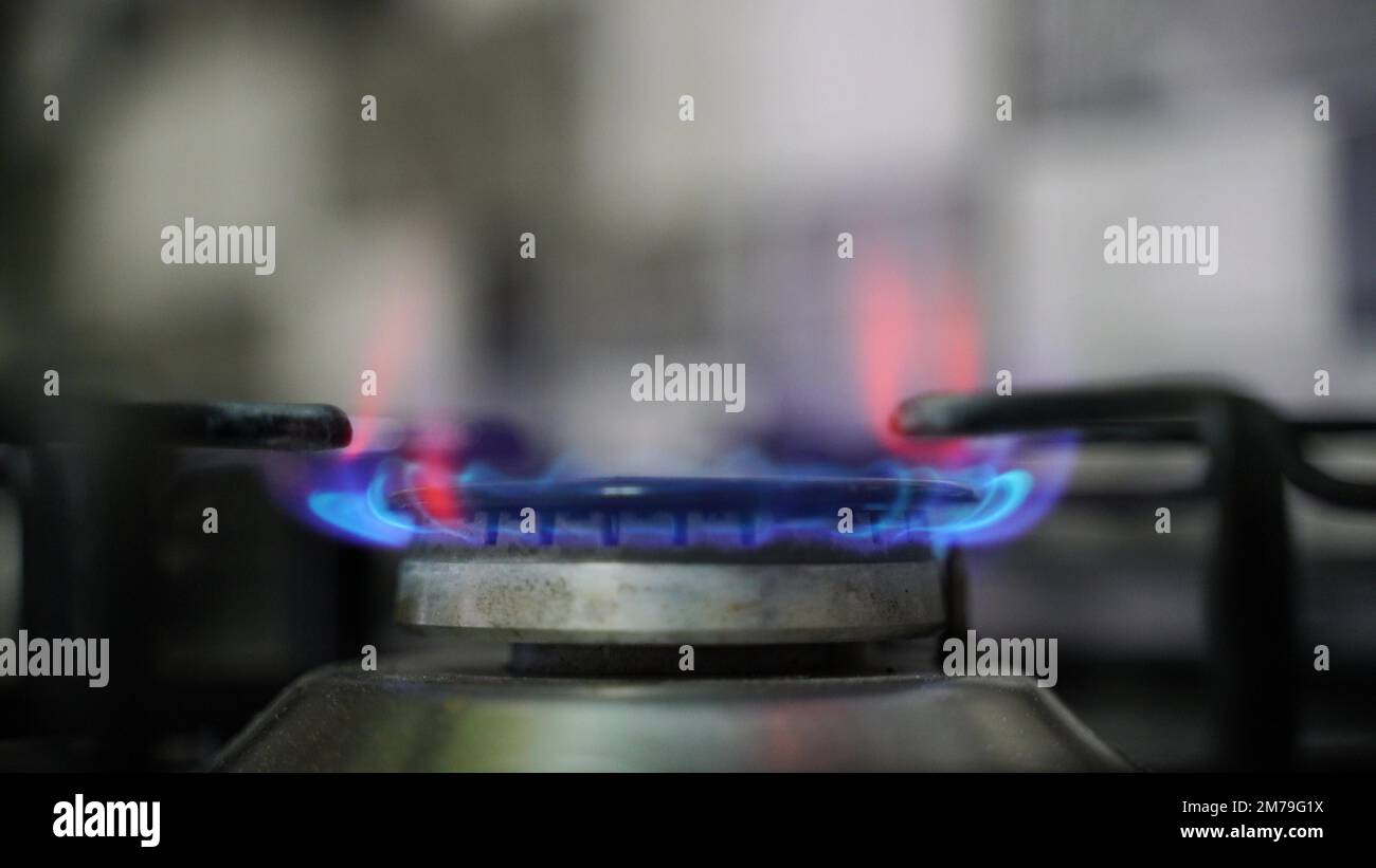 Kitchen burner turning on. Stove top burner igniting into a blue