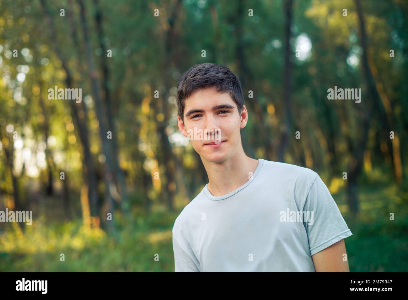 The boy is leaning to one side. The young man smiles. Man walkin Stock