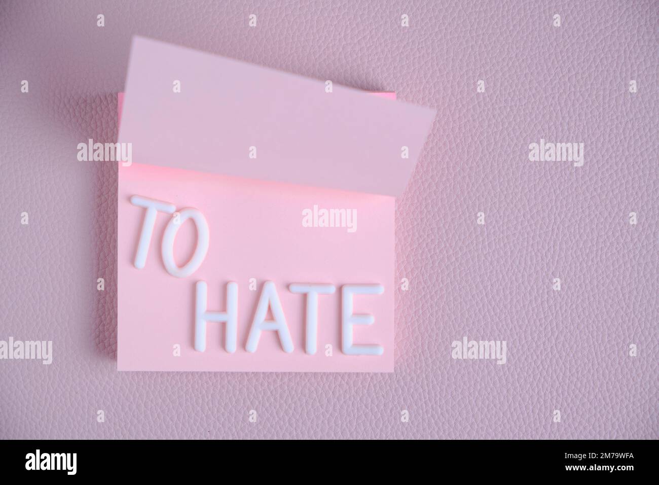 Word hate laid out white letters pink piece paper.Concept hatred, anger and denial Stock Photo