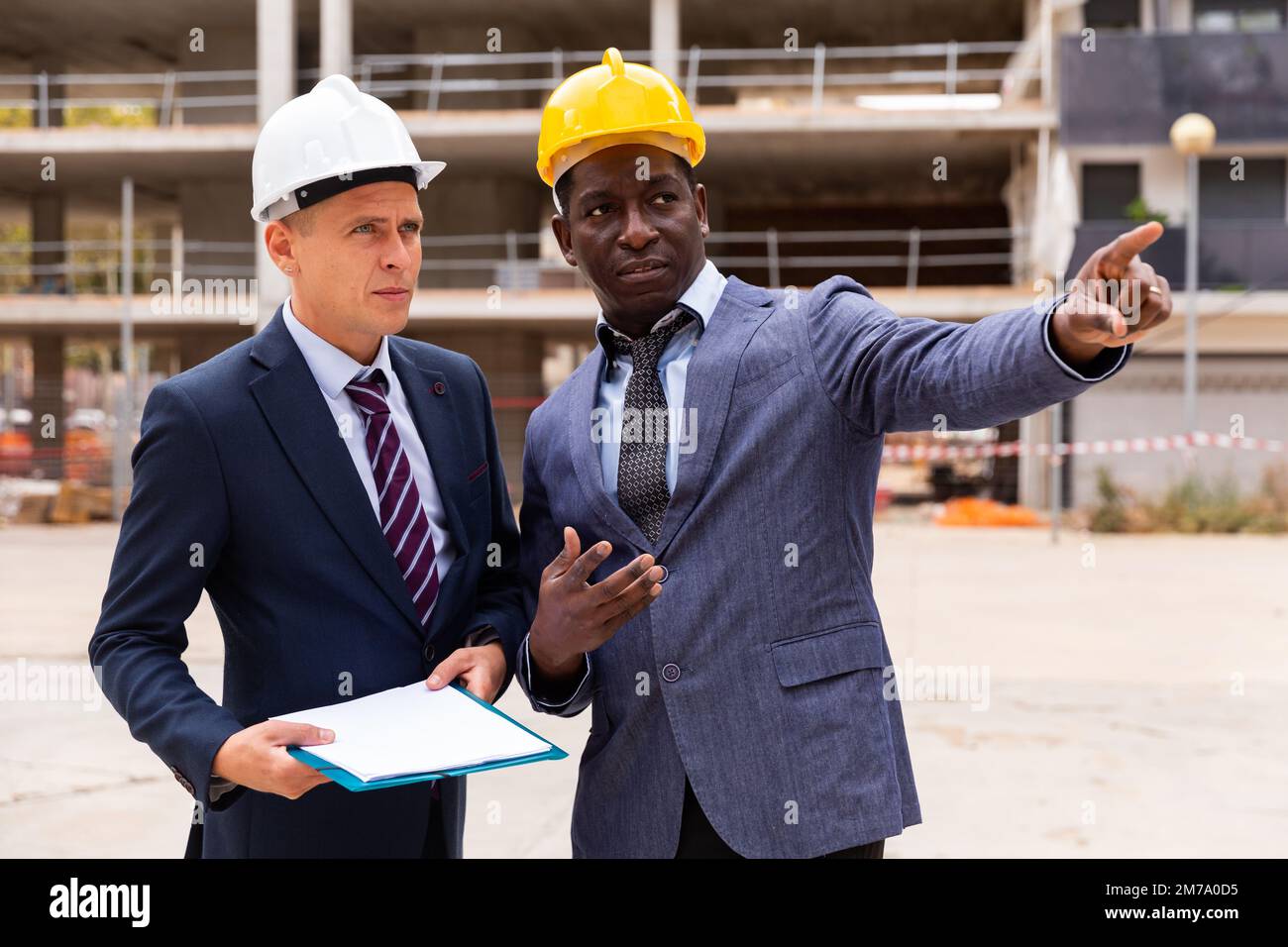 Architects talking about project documentation on construction plant Stock Photo