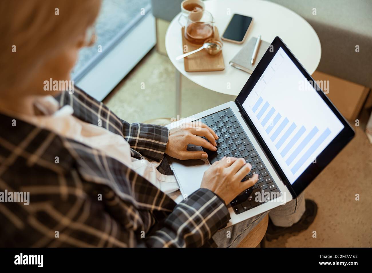 Close up of middle aged businesswoman using laptop works with statistical data in cozy cafe Stock Photo