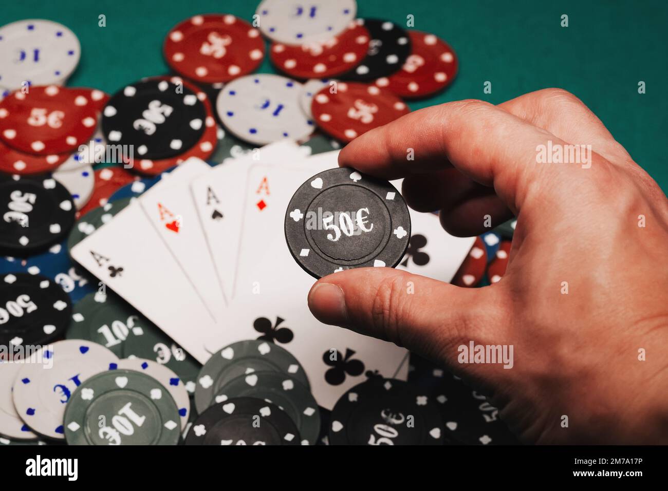 four of a kind of aces on a pile of gaming chips on the green table in the casino closeup