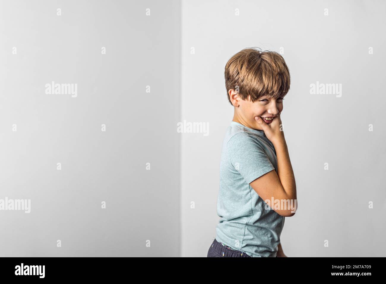 A pre-teen tween boy making a funny scrunched up face with a white background and copy space Stock Photo