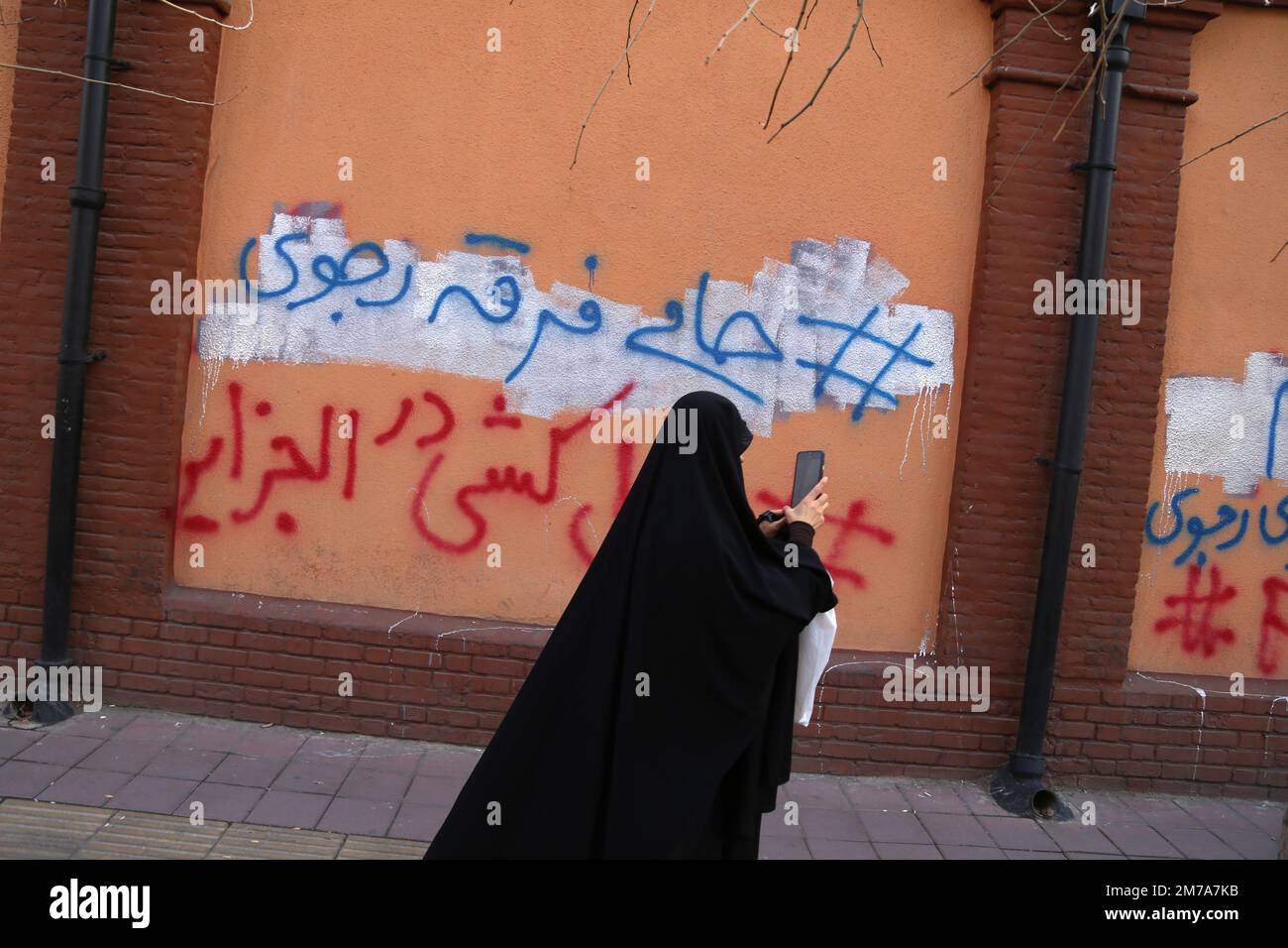 Tehran, Tehran, Iran. 8th Jan, 2023. A veiled Iranian protester walks past  graffiti on a wall of the France embassy after a protest gathering against Charlie  Hebdo, a French satirical weekly magazine,