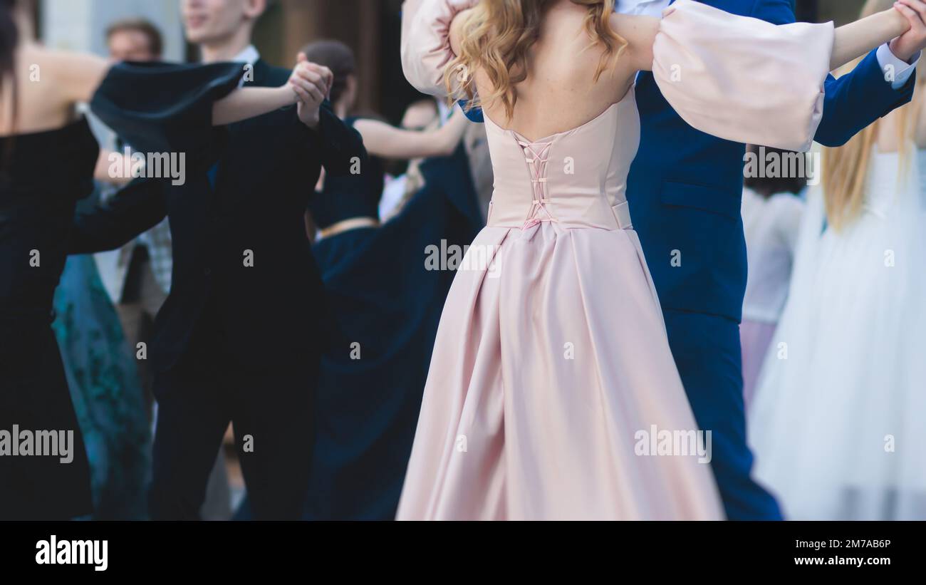 High school graduates dancing waltz and classical ball dance in dresses