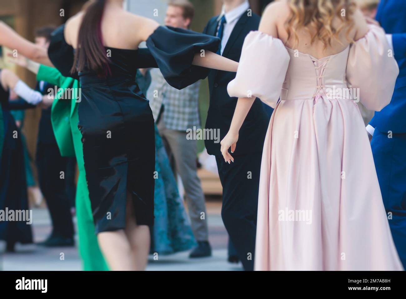 High school graduates dancing waltz and classical ball dance in dresses