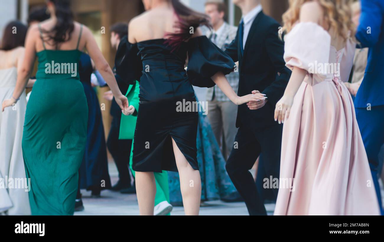 High school graduates dancing waltz and classical ball dance in dresses