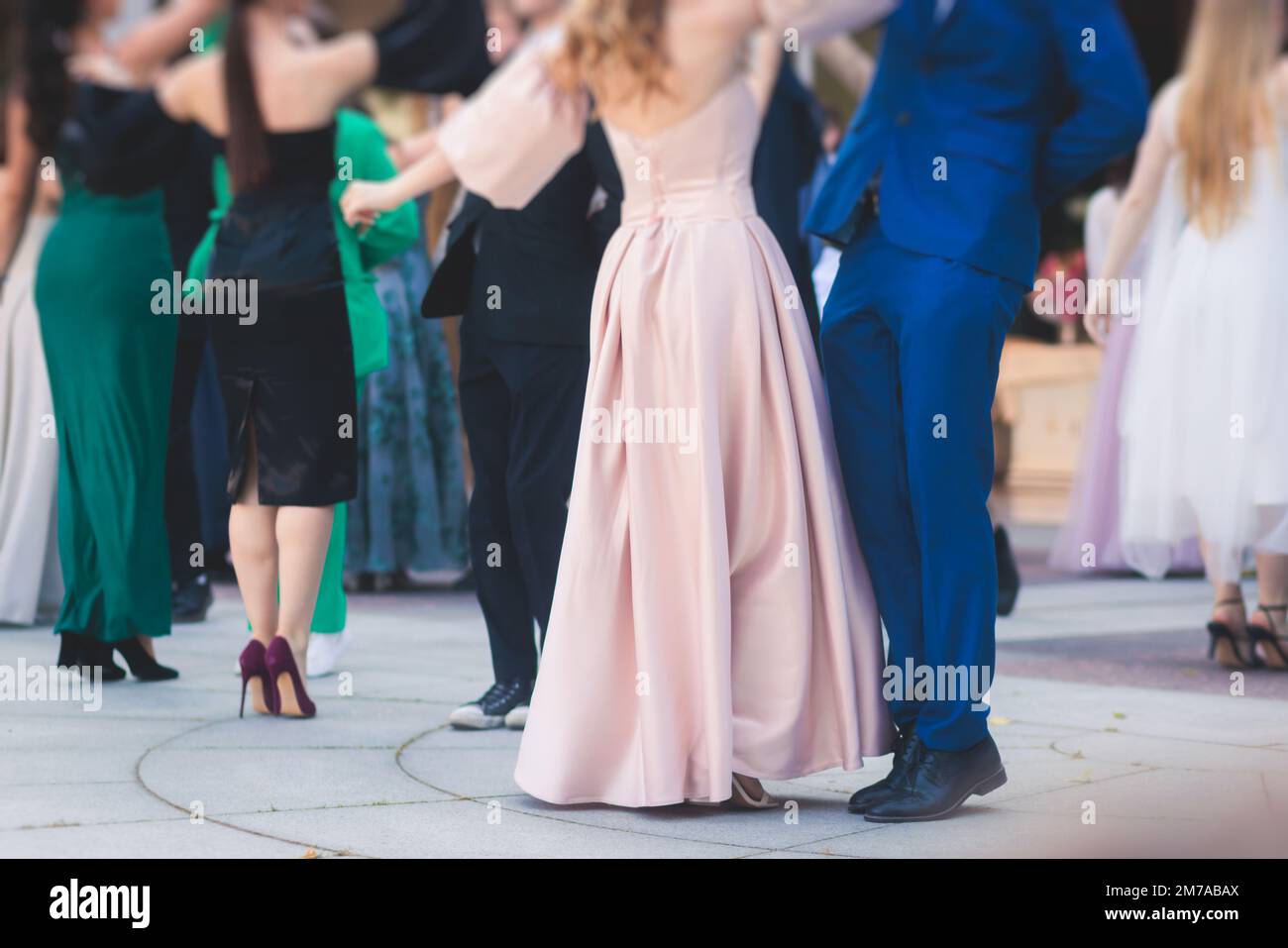 High school graduates dancing waltz and classical ball dance in dresses