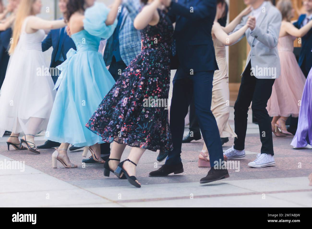 High school graduates dancing waltz and classical ball dance in dresses