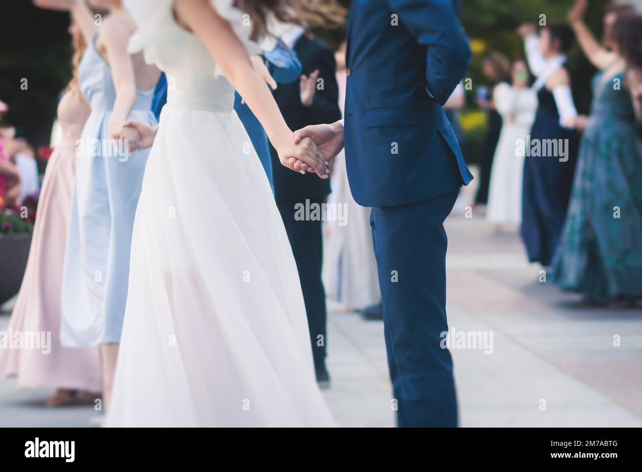 High school graduates dancing waltz and classical ball dance in dresses