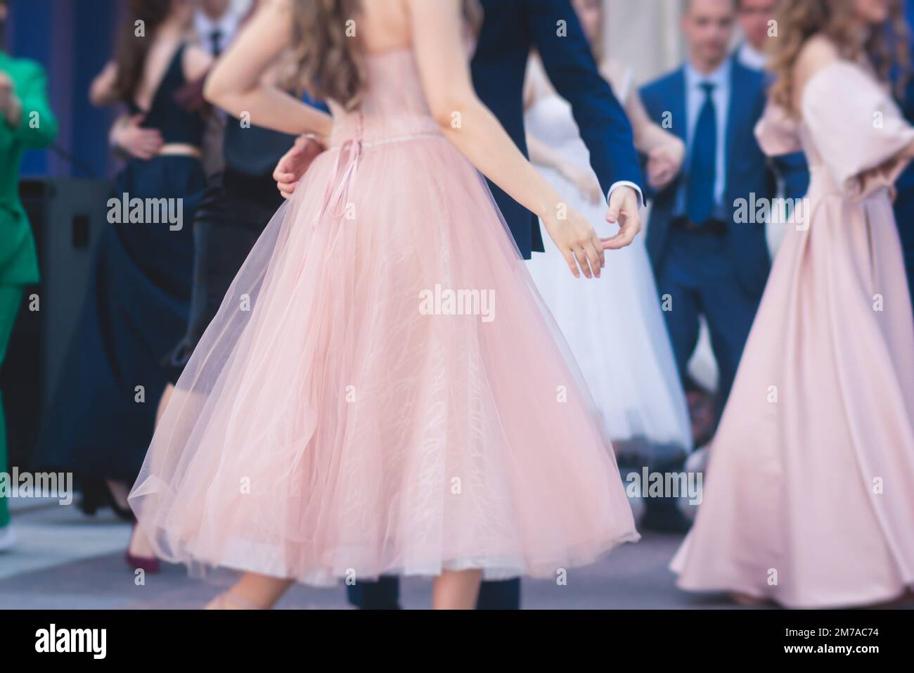 High school graduates dancing waltz and classical ball dance in dresses
