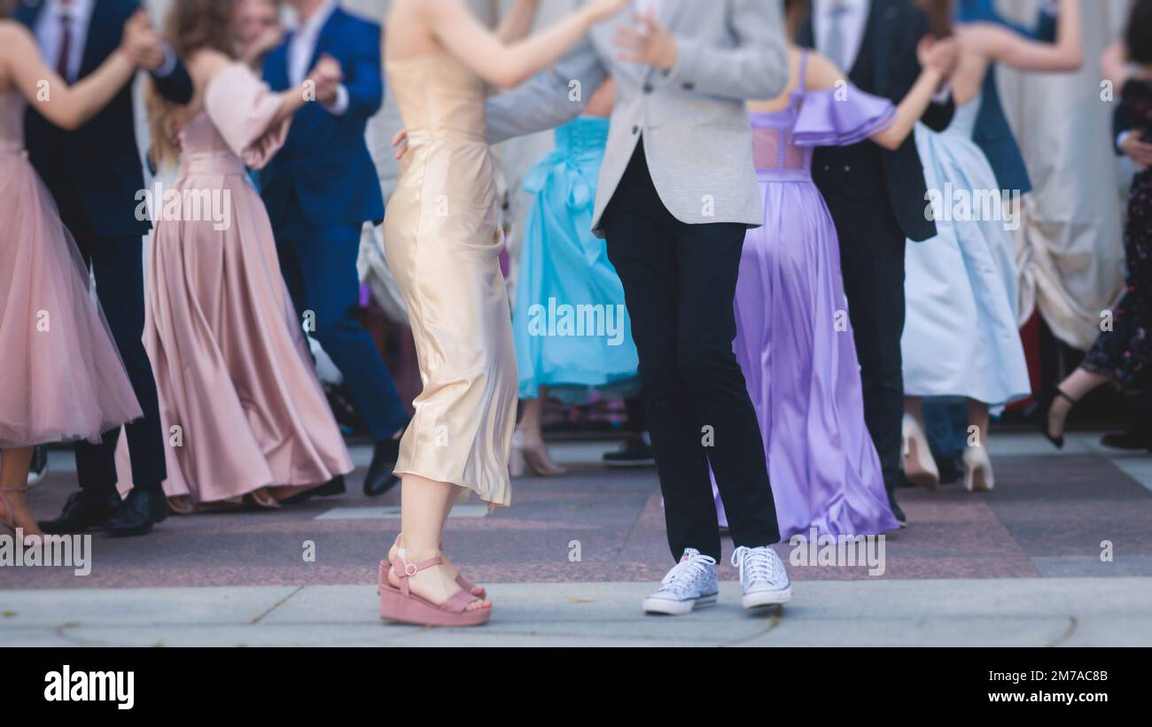 High school graduates dancing waltz and classical ball dance in dresses