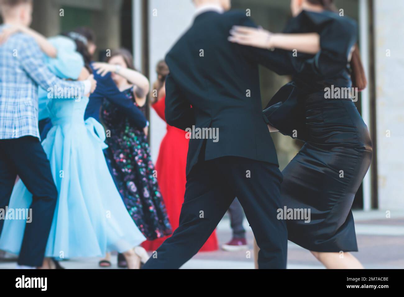 High school graduates dancing waltz and classical ball dance in dresses