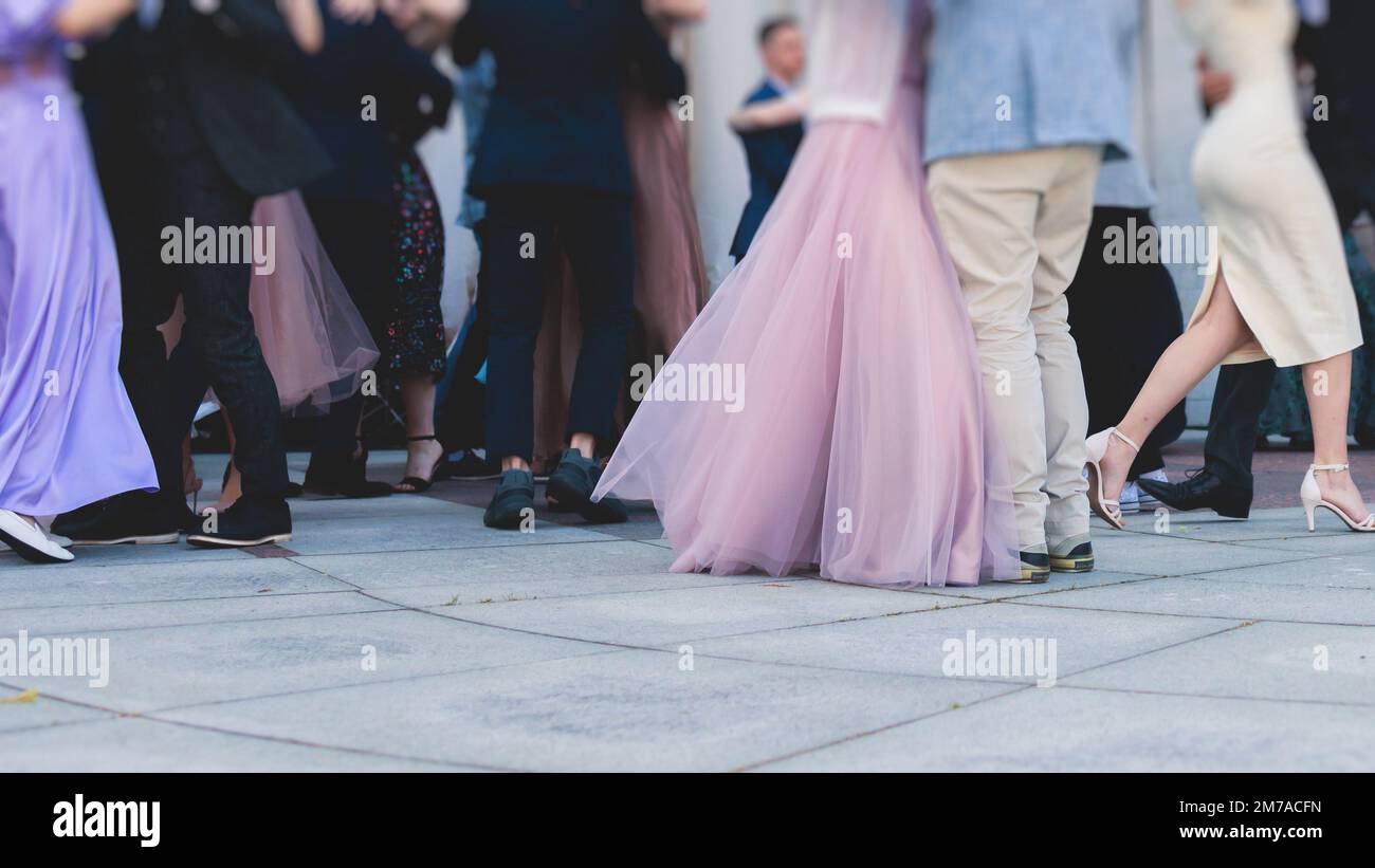 High school graduates dancing waltz and classical ball dance in dresses